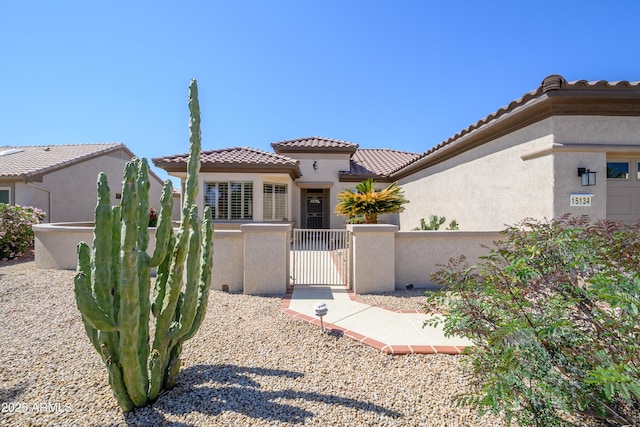 15134 W Waterford Dr, Surprise, AZ 85374 - mediterranean / spanish home with a fenced front yard, stucco siding, a tile roof, and a gate