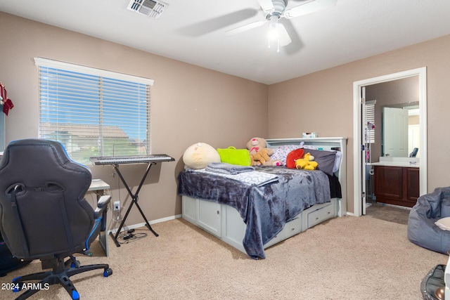 bedroom featuring ceiling fan, connected bathroom, and light carpet