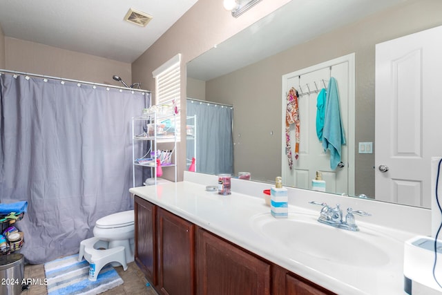 bathroom featuring vanity, toilet, and curtained shower