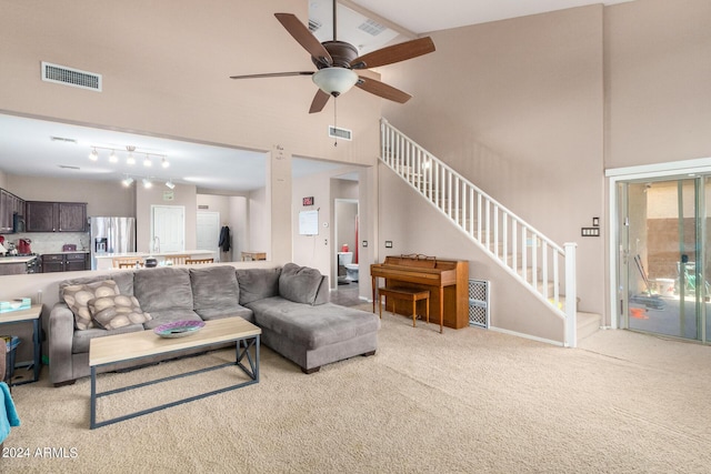 living room with high vaulted ceiling, light colored carpet, and ceiling fan