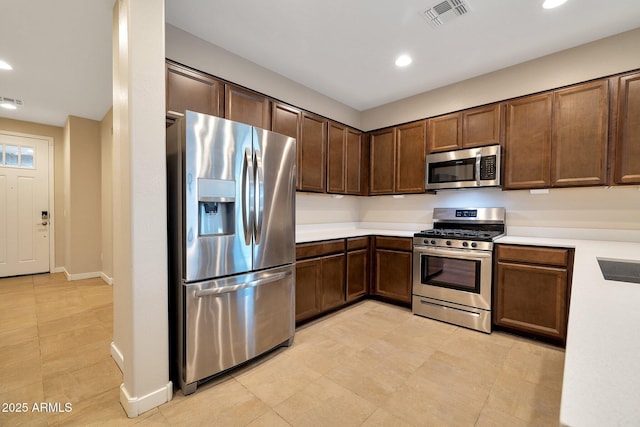 kitchen featuring appliances with stainless steel finishes, sink, and dark brown cabinets