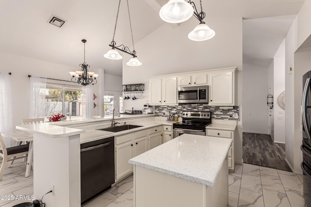 6156 W Del Rio St, Chandler, AZ 85226 - kitchen with appliances with stainless steel finishes, light marble finish floors, a sink, a peninsula, and a chandelier