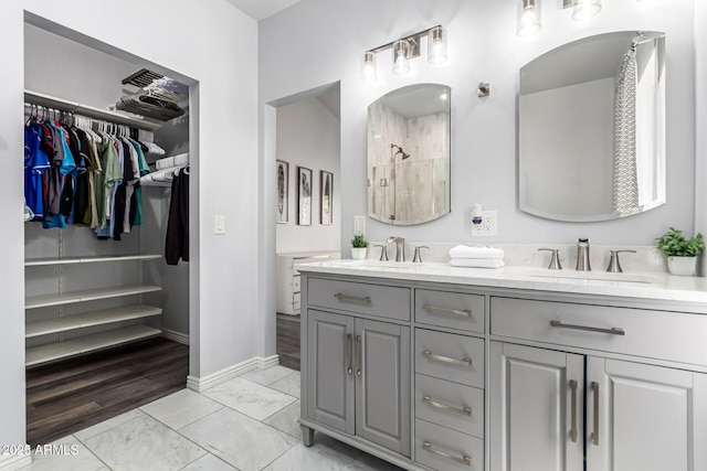 6156 W Del Rio St, Chandler, AZ 85226 - full bathroom featuring double vanity, baseboards, a walk in closet, tiled shower, and marble look tiles