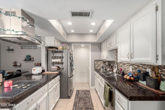 kitchen with light tile patterned flooring, visible vents, stainless steel appliances, dark countertops, and backsplash