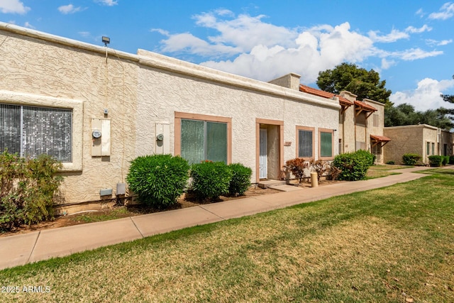 view of front of property with stucco siding and a front yard