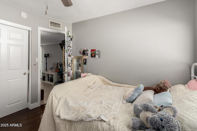 bedroom with dark wood-type flooring, ceiling fan, and visible vents