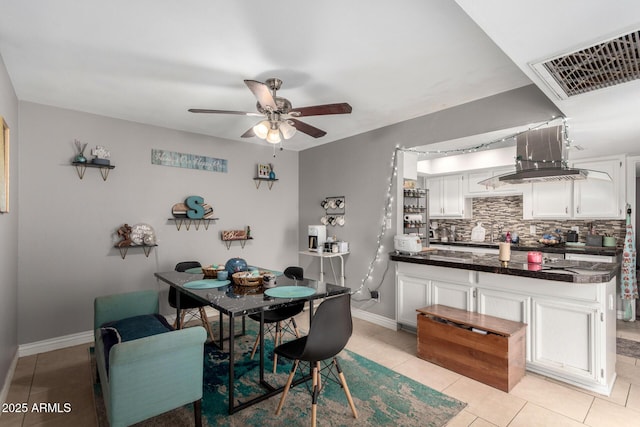 dining room with light tile patterned floors, baseboards, visible vents, and a ceiling fan