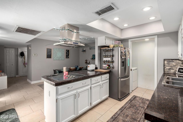 kitchen featuring stainless steel fridge with ice dispenser, visible vents, a peninsula, and a sink