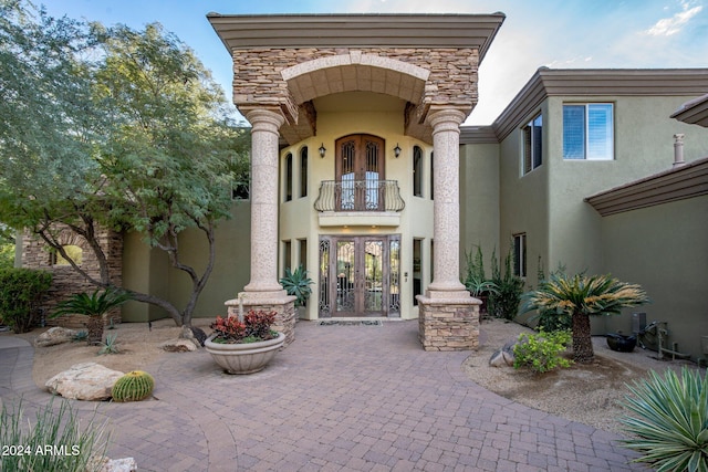 property entrance with a balcony and french doors