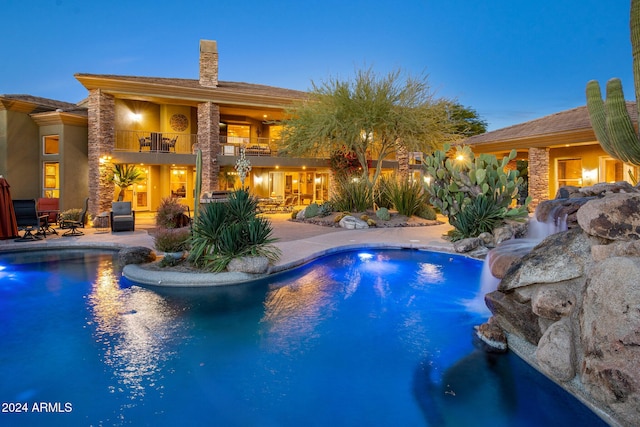 pool at dusk featuring a patio