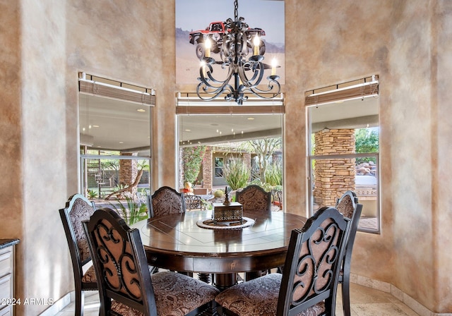 dining room featuring a towering ceiling and a notable chandelier