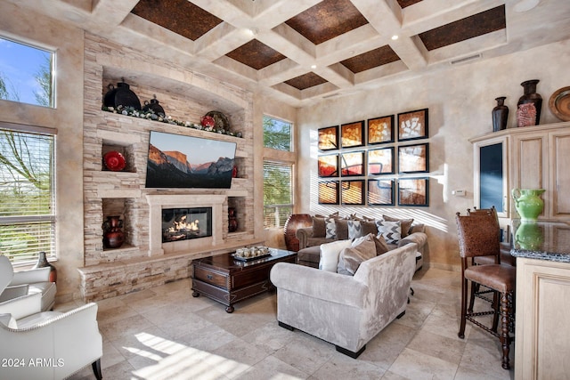 living room featuring beam ceiling, a fireplace, a high ceiling, and coffered ceiling