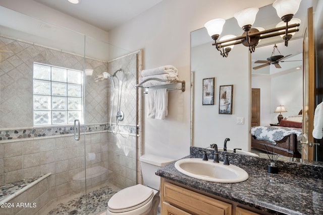 bathroom with ceiling fan, a shower with door, vanity, and toilet