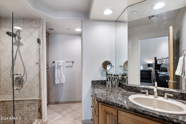 bathroom featuring tile patterned flooring, vanity, and a shower with shower door