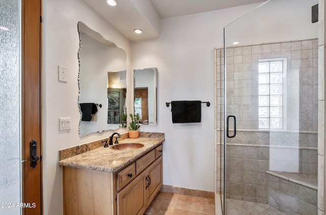 bathroom with tile patterned floors, vanity, and an enclosed shower