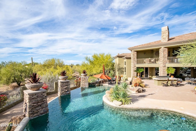 view of pool featuring an outdoor kitchen and a patio