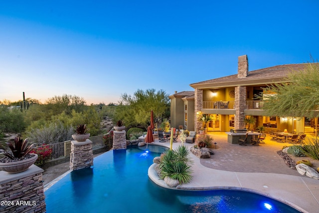 pool at dusk with a patio