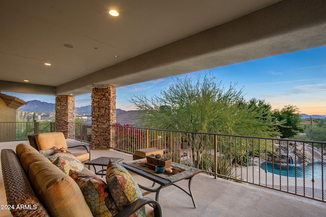 patio terrace at dusk featuring a fenced in pool, a mountain view, and an outdoor hangout area