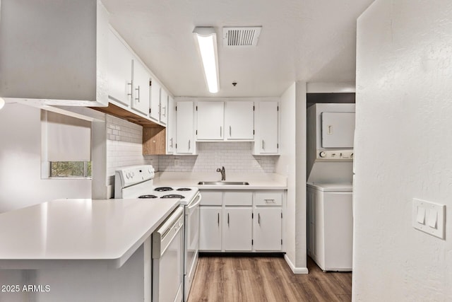 12221 W Bell Rd Unit 249, Surprise, AZ 85378 - kitchen with white appliances, stacked washer and clothes dryer, a sink, light wood-style floors, and decorative backsplash
