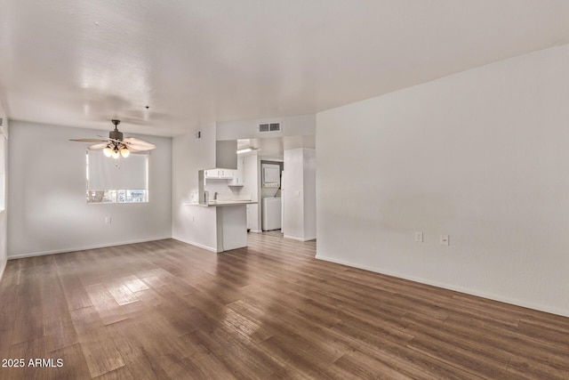 12221 W Bell Rd Unit 249, Surprise, AZ 85378 - unfurnished living room with wood finished floors, a ceiling fan, washer / dryer, and baseboards