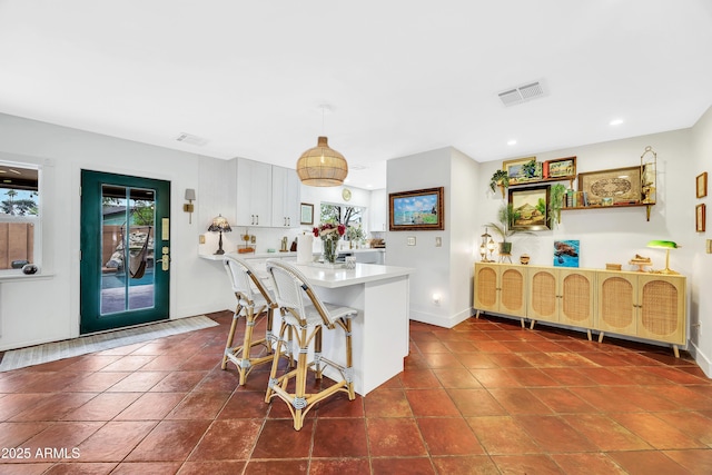 kitchen with plenty of natural light, a breakfast bar area, and dark tile patterned flooring