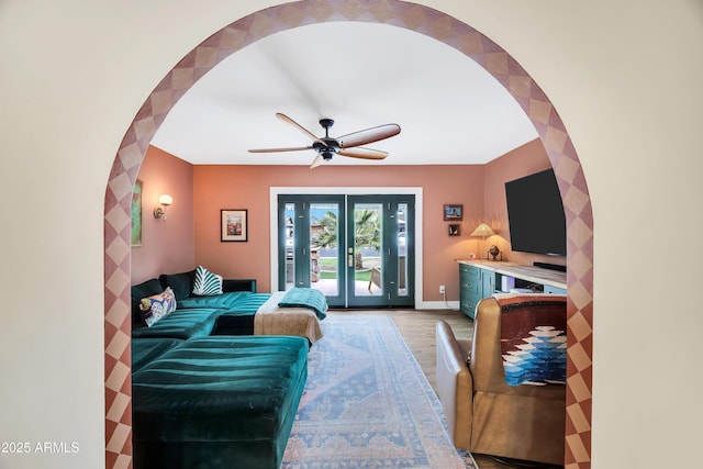 living room with wood-type flooring, french doors, and ceiling fan