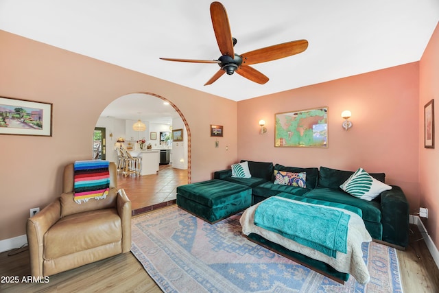 living room with light hardwood / wood-style flooring and ceiling fan