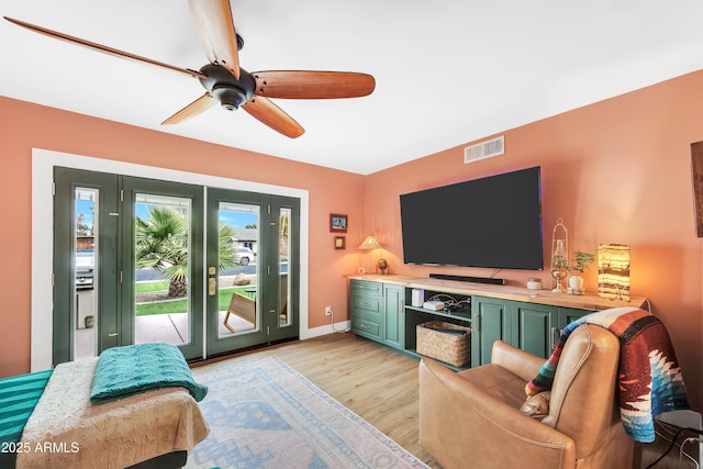 living room featuring ceiling fan and light hardwood / wood-style flooring