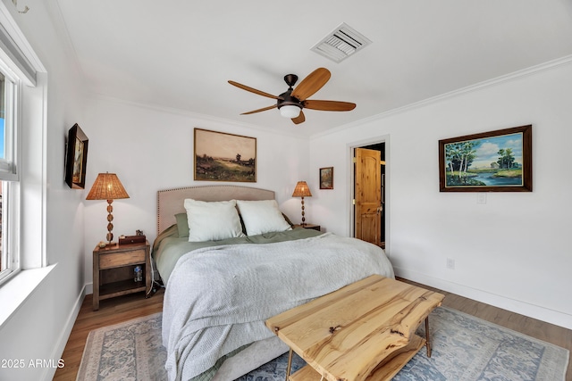 bedroom with hardwood / wood-style flooring, ceiling fan, and crown molding