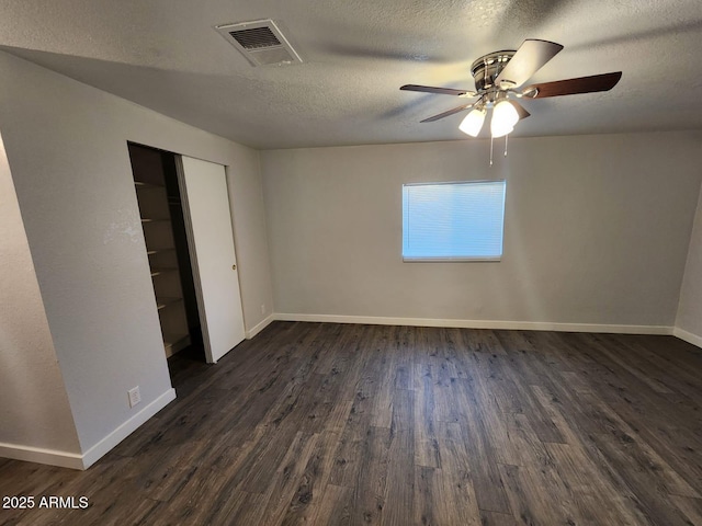 unfurnished bedroom featuring a closet, a textured ceiling, ceiling fan, and dark hardwood / wood-style flooring