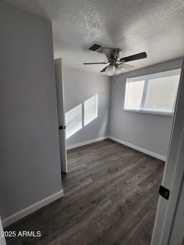 spare room with a textured ceiling, dark hardwood / wood-style flooring, and ceiling fan