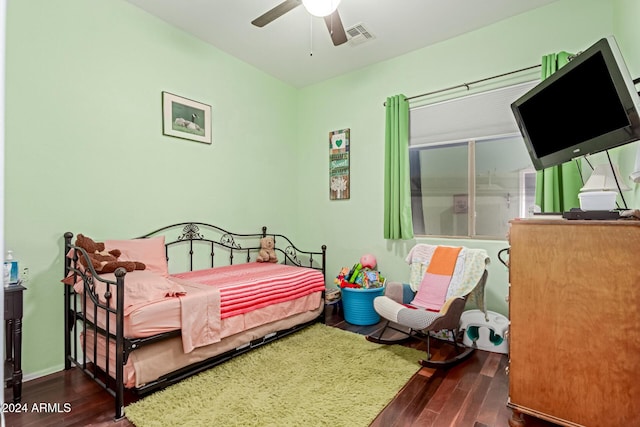 bedroom with dark hardwood / wood-style flooring and ceiling fan