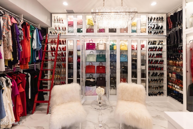 spacious closet featuring a notable chandelier