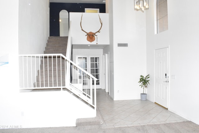 staircase featuring tile patterned floors and a towering ceiling