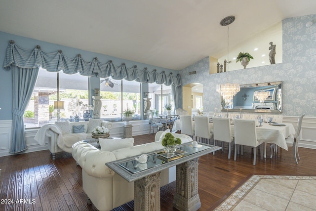 living room with vaulted ceiling, a notable chandelier, wood-type flooring, and plenty of natural light