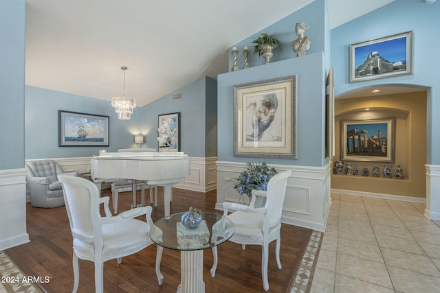 dining area with light tile patterned floors, lofted ceiling, and an inviting chandelier