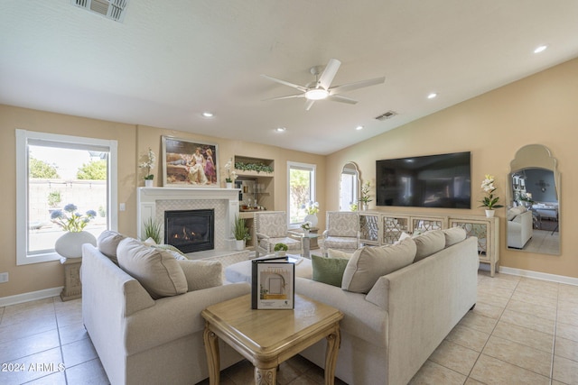 living room with ceiling fan, a healthy amount of sunlight, vaulted ceiling, and light tile patterned flooring