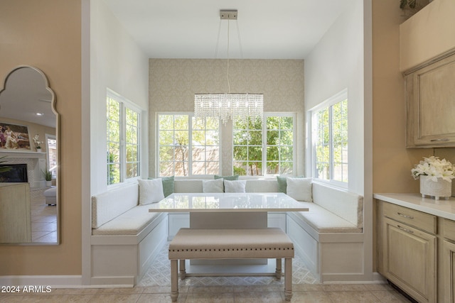 sunroom / solarium featuring breakfast area, an inviting chandelier, and plenty of natural light