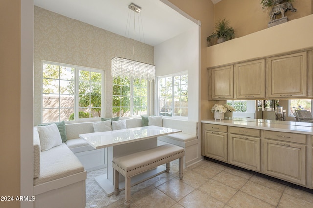 kitchen with light brown cabinetry, kitchen peninsula, breakfast area, and plenty of natural light