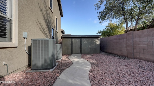 view of yard with cooling unit and a storage shed