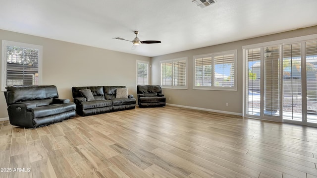 living room with light hardwood / wood-style flooring and ceiling fan