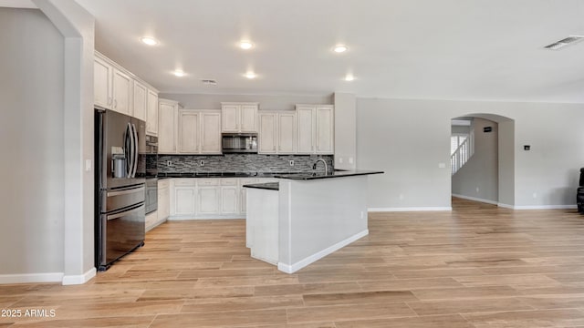 kitchen with white cabinetry, appliances with stainless steel finishes, tasteful backsplash, and light wood-type flooring