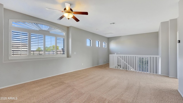 carpeted spare room with ceiling fan