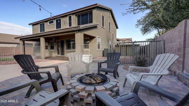 back of property featuring central AC, a patio area, and an outdoor fire pit