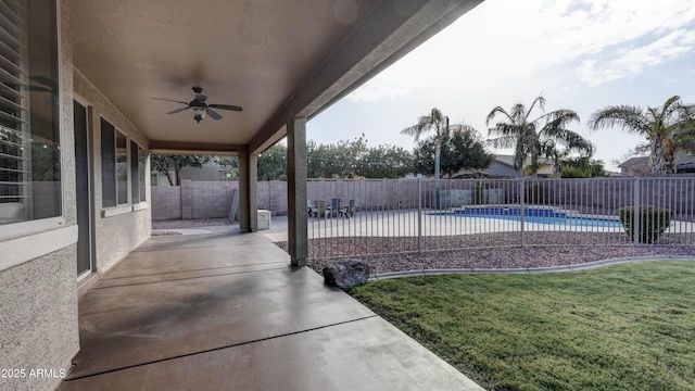 view of swimming pool featuring a patio area, ceiling fan, and a lawn