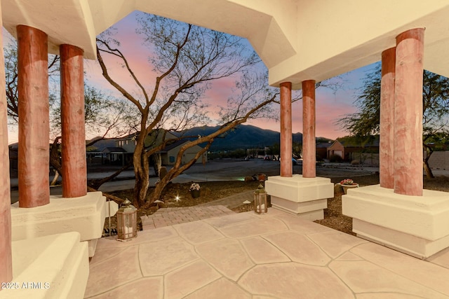 patio terrace at dusk featuring a mountain view