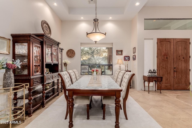 dining room featuring a tray ceiling and a towering ceiling