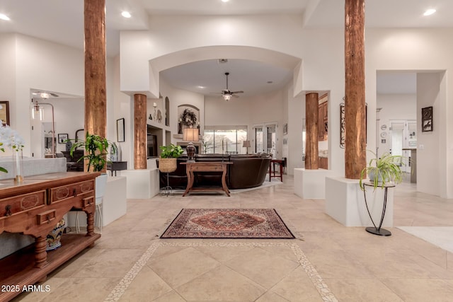 interior space featuring ceiling fan and a towering ceiling