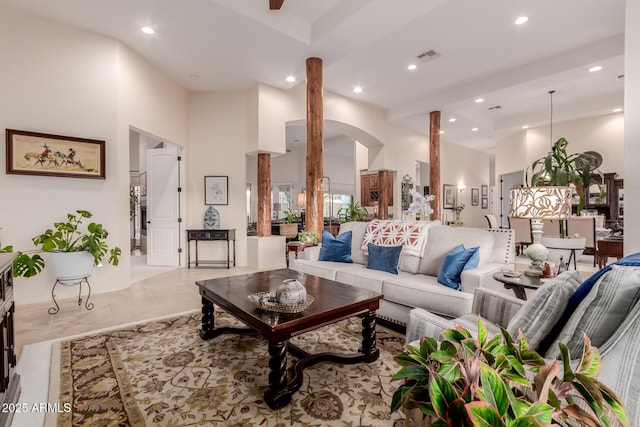 living room with decorative columns and a high ceiling