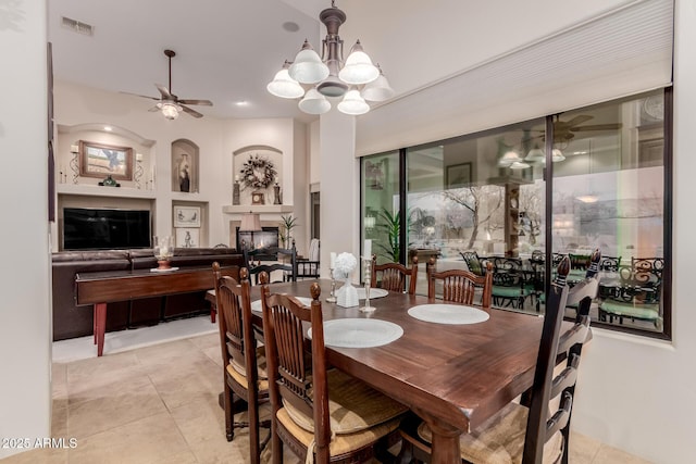 tiled dining room with ceiling fan with notable chandelier